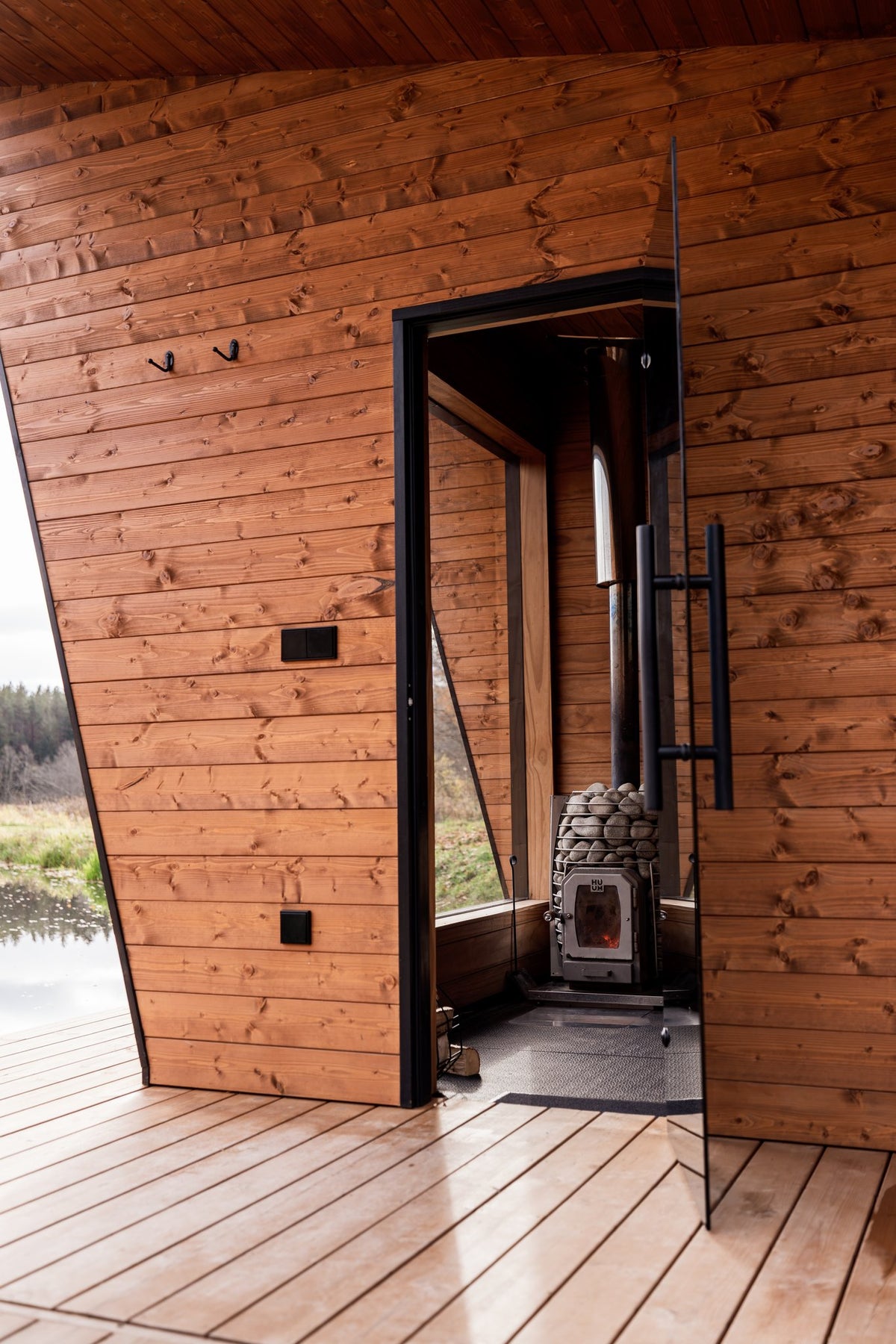 HUUM HIVE Wood 17 sauna stove seen through the door of a sauna cabin