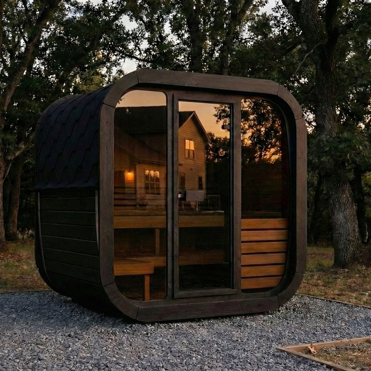 SaunaLife CL5G Cube Series 4-Person Outdoor Sauna Kit, black finish, in a garden at dusk