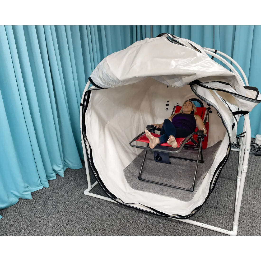 Summit to Sea soft shell hyperbaric chamber set up in a room with its entry open and a recliner inside