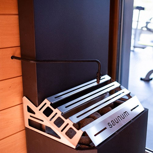 Saunum AutoLeil pipe installed above the basket of a Saunum heater