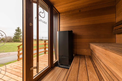 Saunum Air Perfect 7 heater from the package in a wood sauna beside a glass door