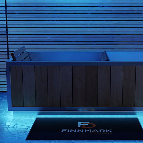 Finnmark SoulCold plunge tub with its LED lighting set to blue, beside a slatted wall