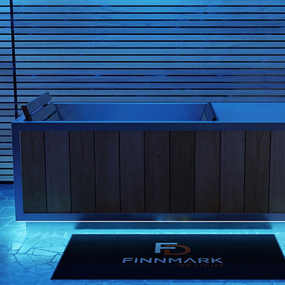 Finnmark SoulCold plunge tub with its LED lighting set to blue, beside a slatted wall