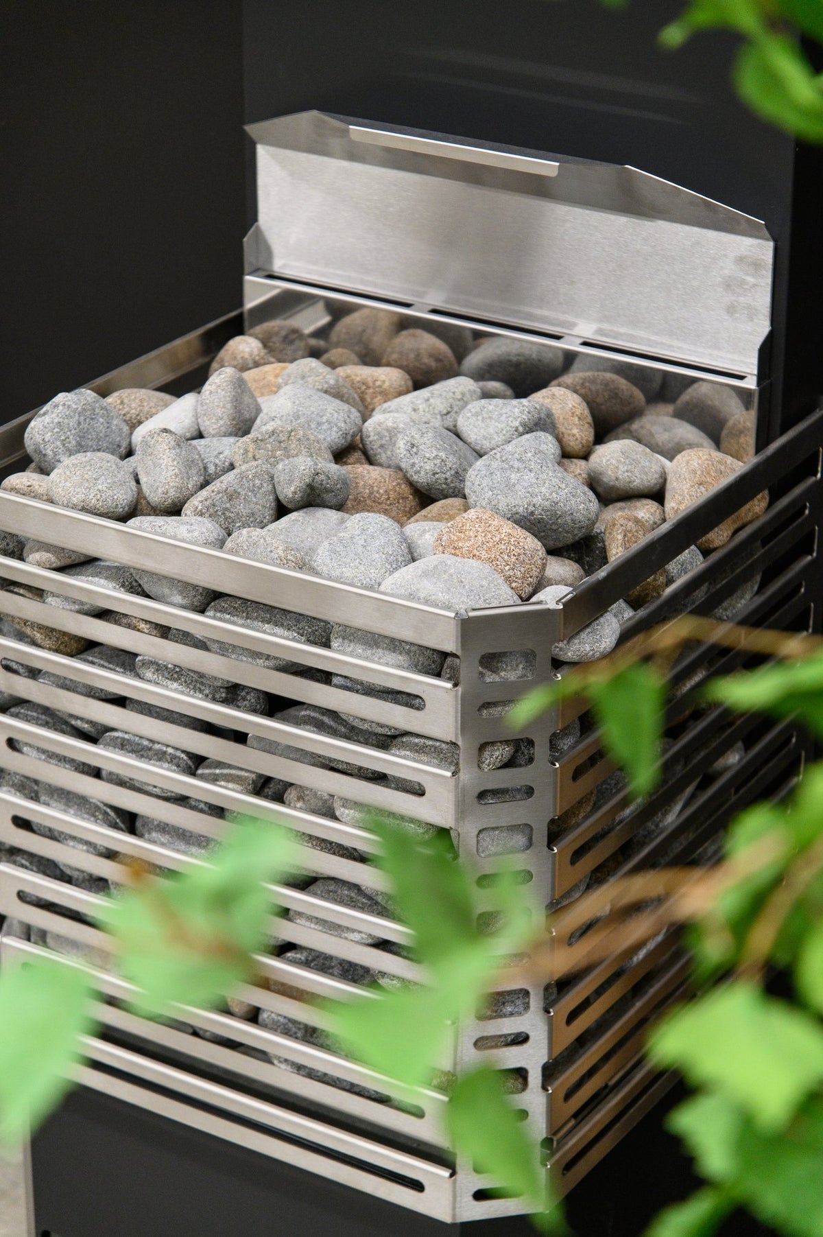 Close-up of the Saunum Air L 10 open stainless steel basket loaded with sauna stones
