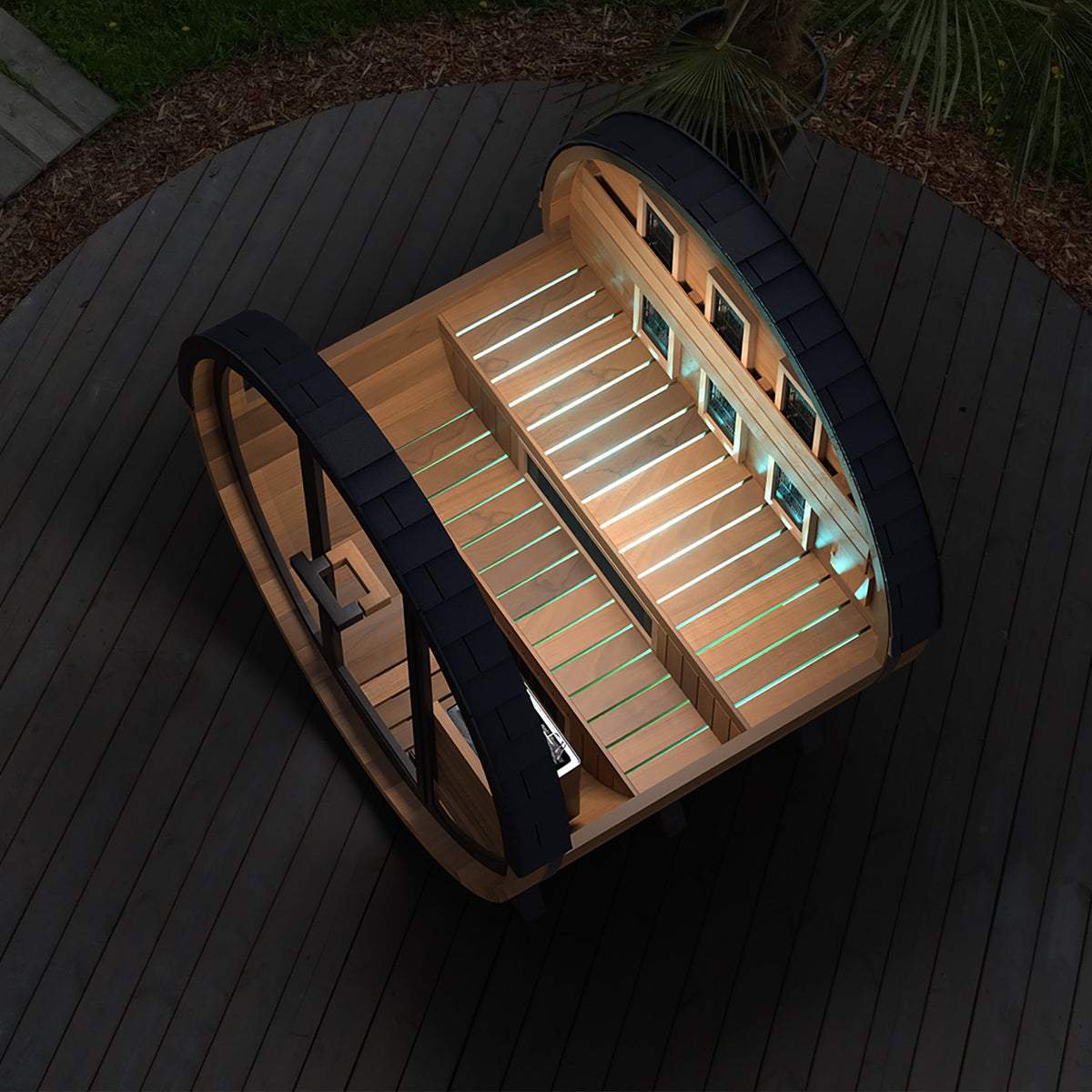 Finnmark FD-6 barrel sauna at night on a deck with the interior LED lighting on and the door open