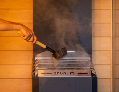 Water ladled over the Saunum Air 5 closed basket top, steam rising
