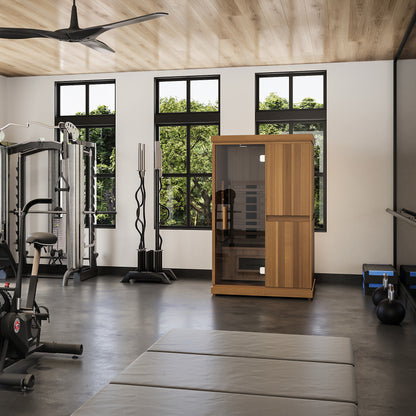 Finnmark FD-2 infrared sauna in a home gym beside a treadmill and a cable machine, showing the cabin at room scale