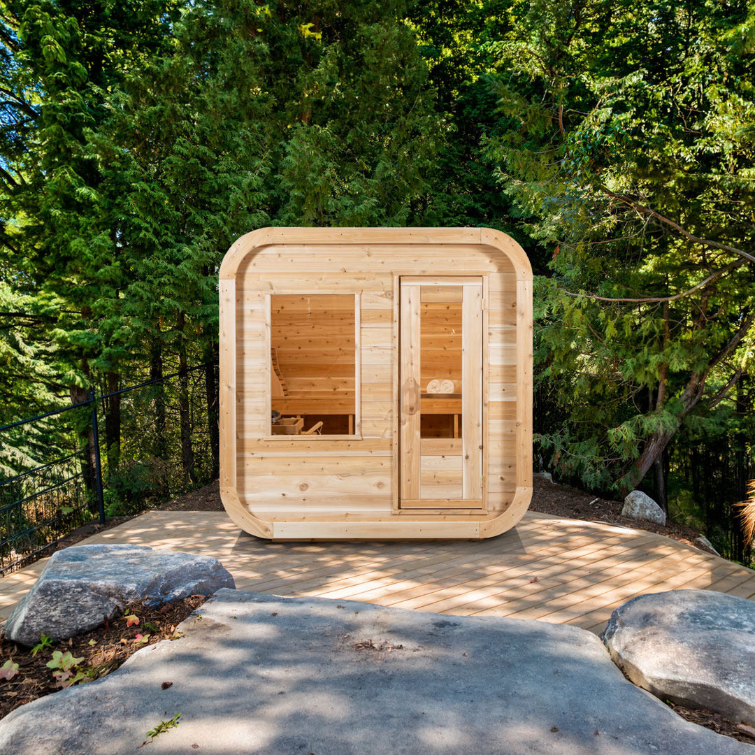 CT Luna outdoor sauna seen front on from a stone patio, with the glass door and window and the sloped roof line