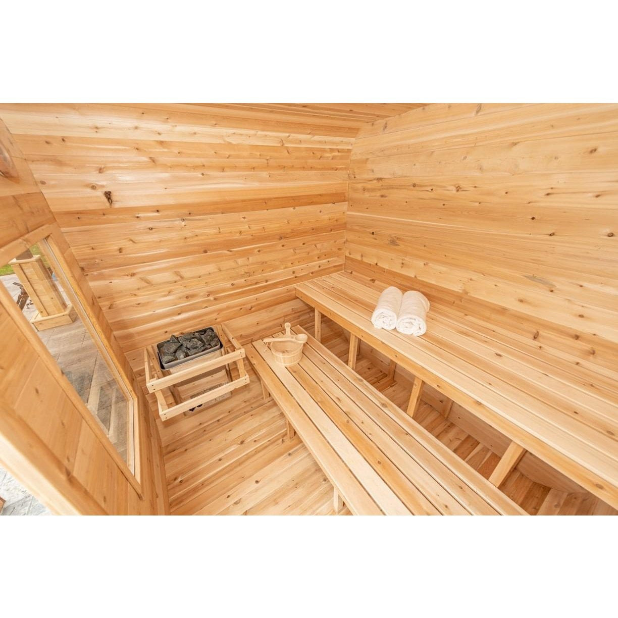 Interior of the CT Luna sauna showing the full L-shaped cedar bench run wrapping two walls with the heater in the corner