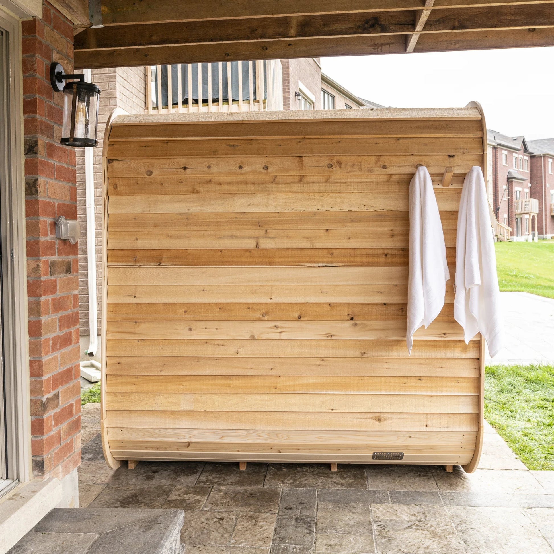CT Luna sauna installed under a covered deck area with a towel hung beside the door
