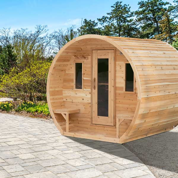 CT Elation sauna from the front corner on a paver patio, door, both front windows and outside benches, siding running the length of the barrel