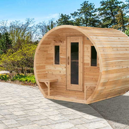 CT Elation sauna from the front corner on a paver patio, door, both front windows and outside benches, siding running the length of the barrel