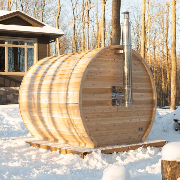 Wood-fired CT Elation sauna in snow with the stainless chimney exiting through the barrel wall