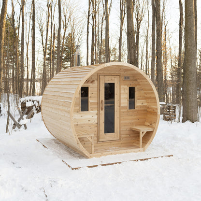 Canadian Timber CT Elation 4 person outdoor barrel sauna in Eastern White Cedar, three-quarter view in snow showing the door, front windows and outside benches