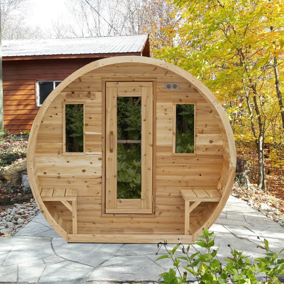 CT Elation sauna beside a house on a stone patio in autumn, front view with the outdoor benches