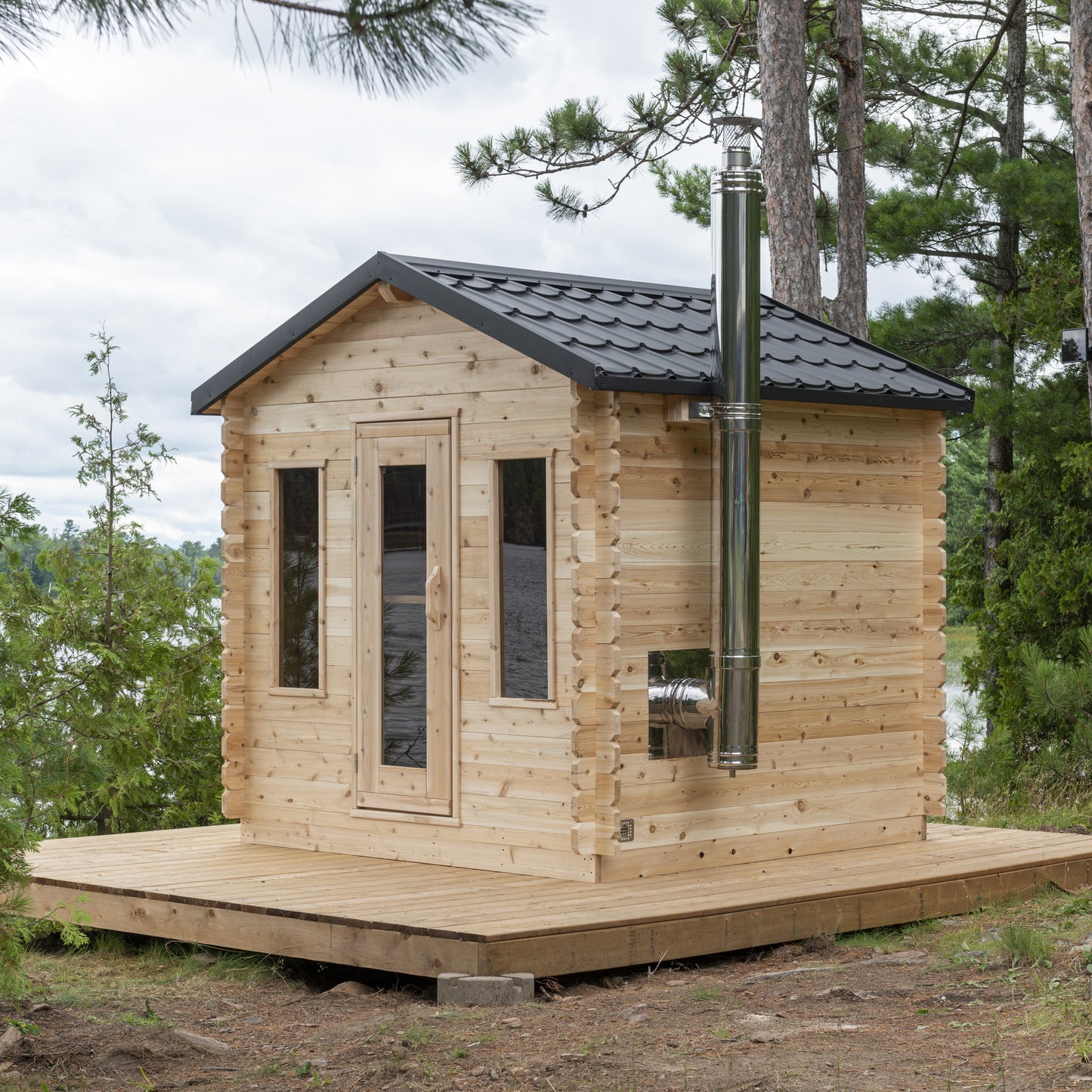 CT Georgian cabin sauna three-quarter front view showing the gable roof, metal shingles and chimney