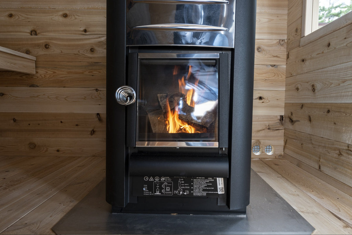 Wood-burning stove with fire in the CT Georgian cabin sauna interior