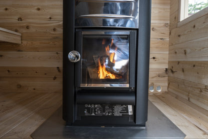 Wood-burning stove with fire in the CT Georgian cabin sauna interior