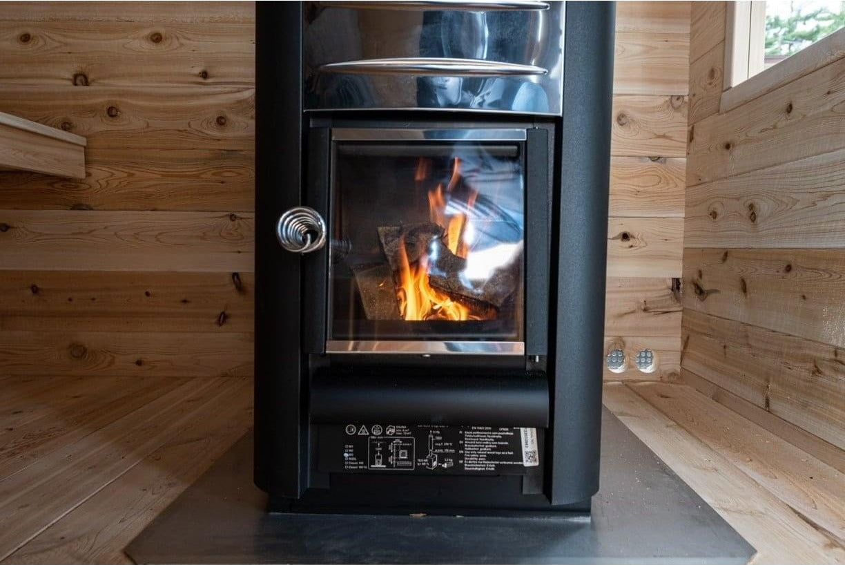 Wood-burning stove with fire in the CT Georgian cabin sauna interior