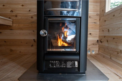 Wood-burning stove with fire in the CT Georgian cabin sauna interior