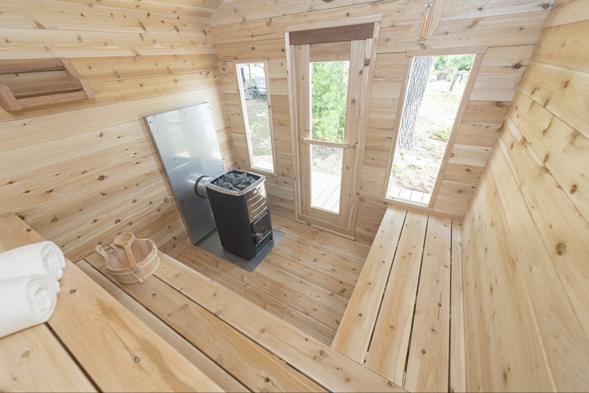 Wide view of the CT Georgian cabin sauna interior with windows, benches and heater