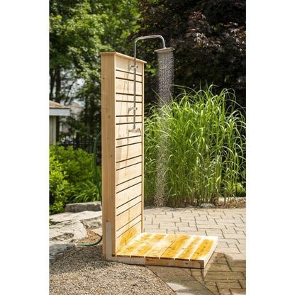 Savannah panel with the rain head running onto the wet cedar pad, ornamental grasses and a green hose beside it, hardware sold separately.