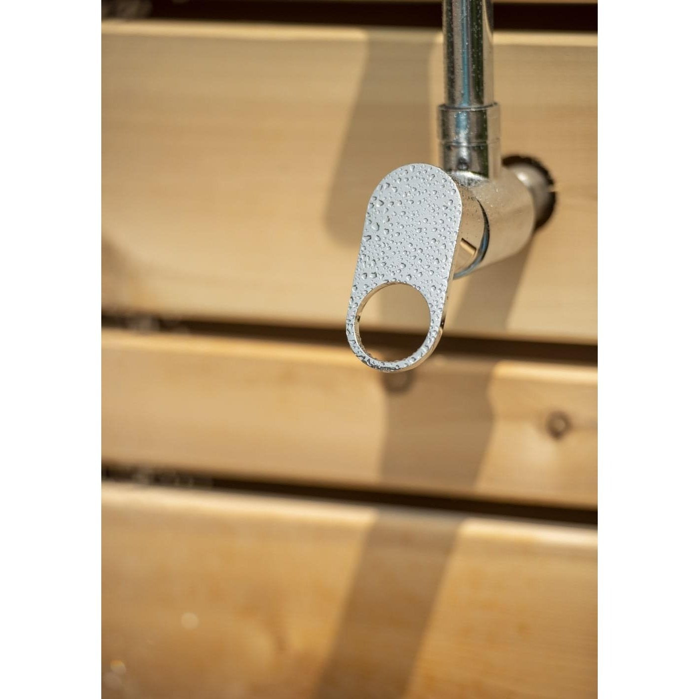 Single chrome lever valve beaded with water on the riser, against the horizontal cedar slats of the Savannah panel, sold separately.