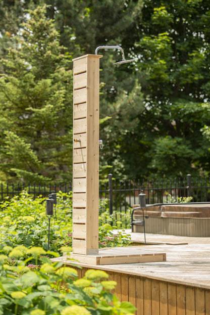 CT Sierra pillar shower on its pad on a wood deck, a hot tub behind it, the round rain head dry and sold separately.