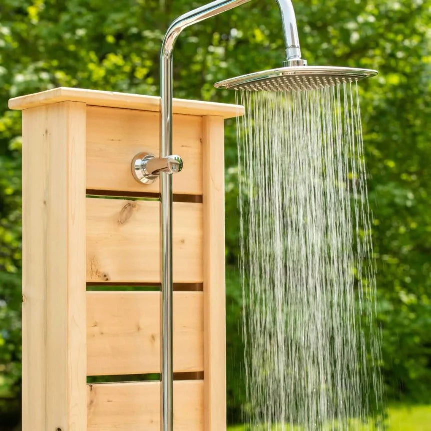 Round chrome rain head spraying against blurred green foliage, mounted on the Sierra pillar riser, the fixture shown is sold separately.