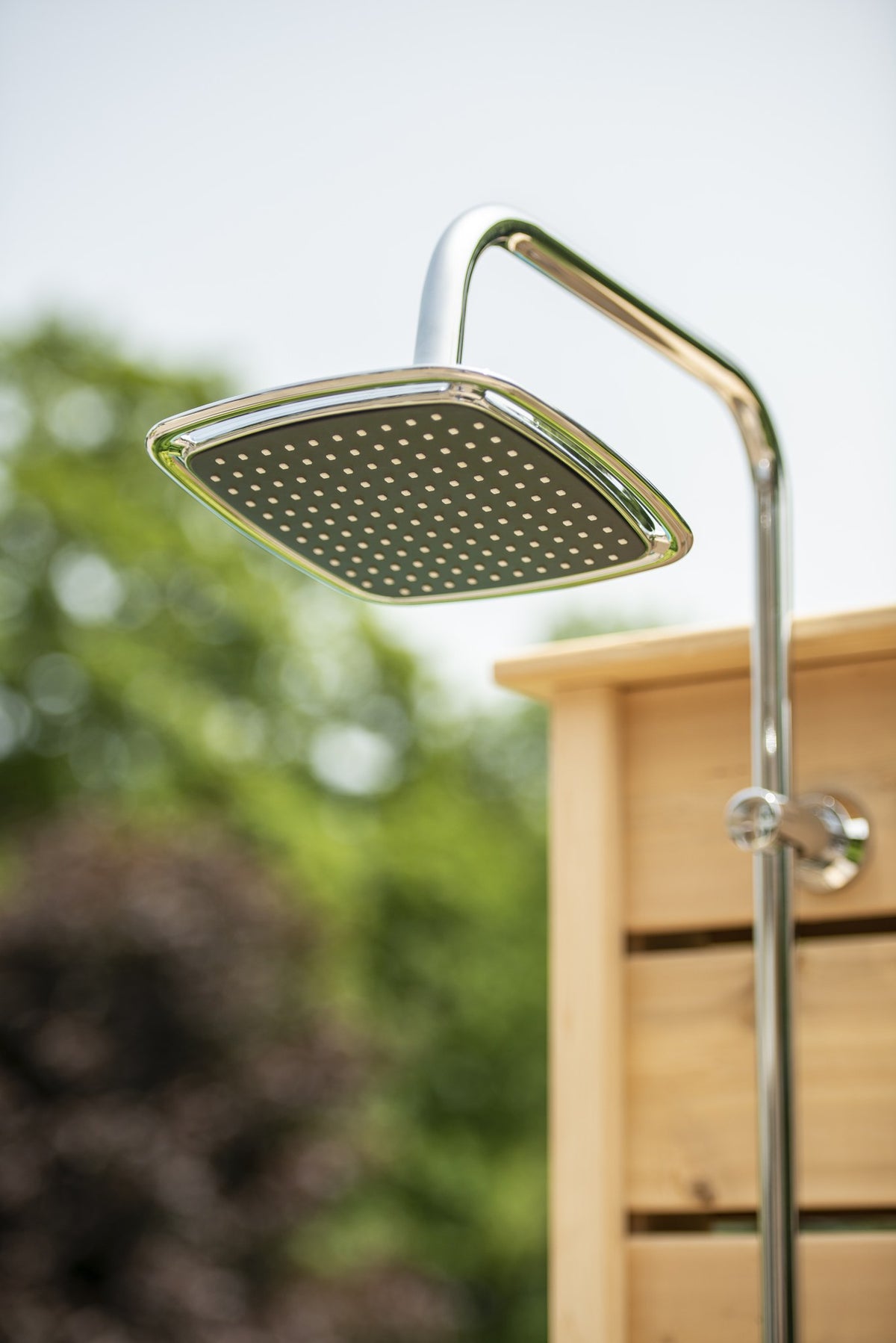 Square chrome rain head, not running, on the chrome riser at the top of the Sierra pillar, sold separately from the shower.