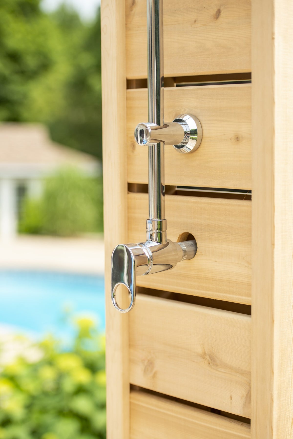 Single chrome lever valve and riser flange on the slatted cedar face of the Sierra pillar, a pool behind, sold separately.