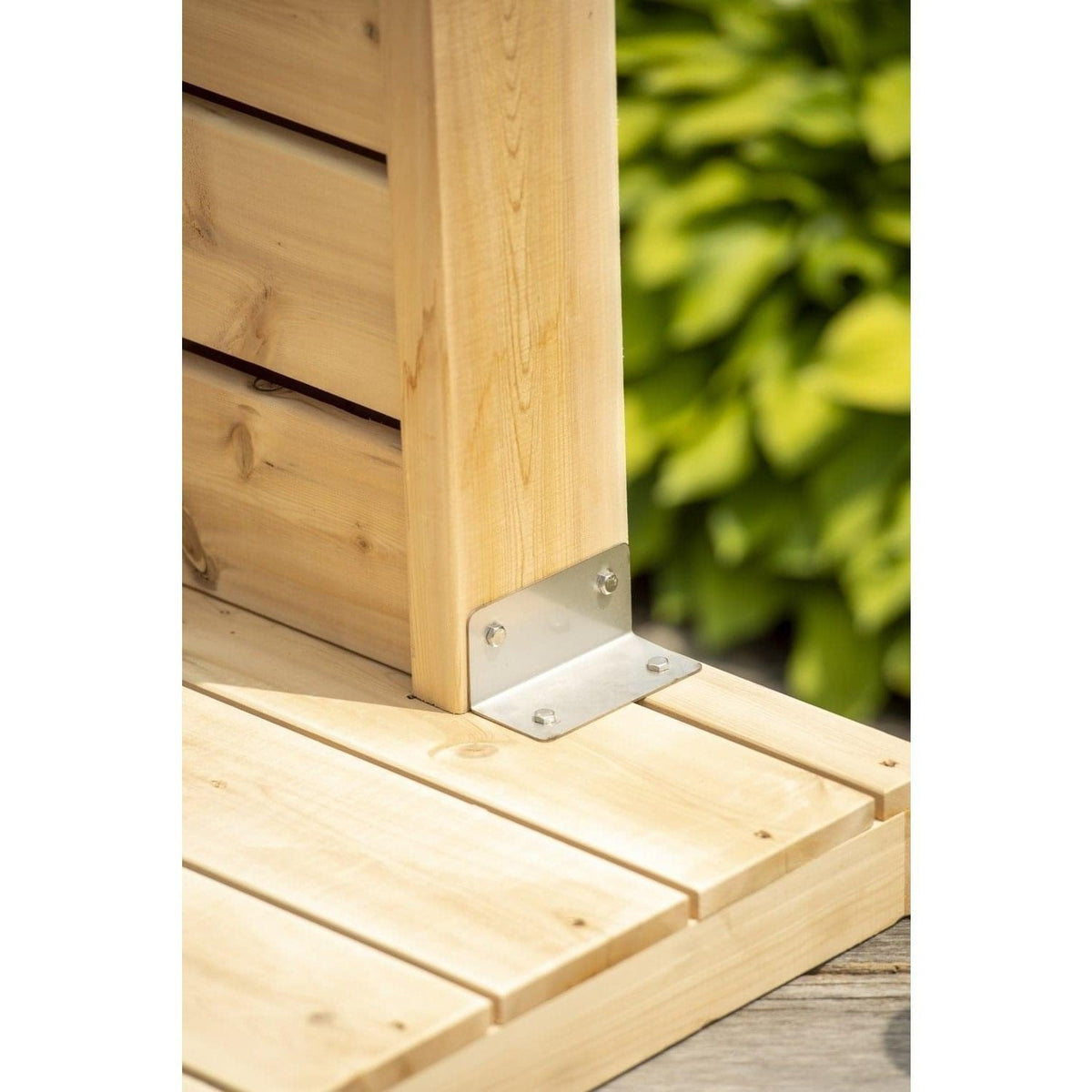 Stainless angle bracket fixing the Sierra shower pillar to its cedar floorboard base pad