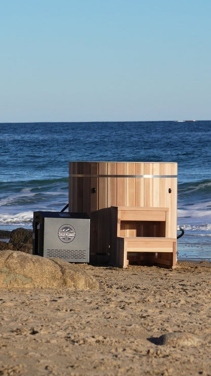 DCT Pacific Cedar Barrel cold plunge with step and chiller, on a beach