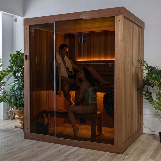 Dundalk LeisureCraft CT Element Loft indoor sauna with two people seated inside, glass front and warm bench lighting