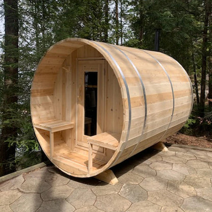 CT Serenity barrel sauna on a stone patio, porch benches either side of the cedar door
