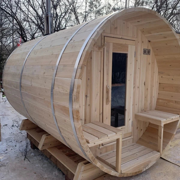 CT Serenity barrel sauna standing in snow, showing the covered porch and the full barrel length