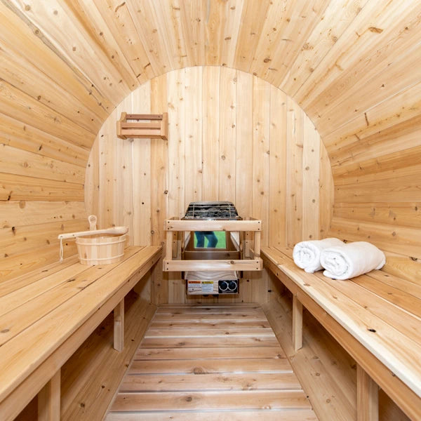 Inside the CT Serenity barrel sauna: facing cedar benches, heater and slatted floor