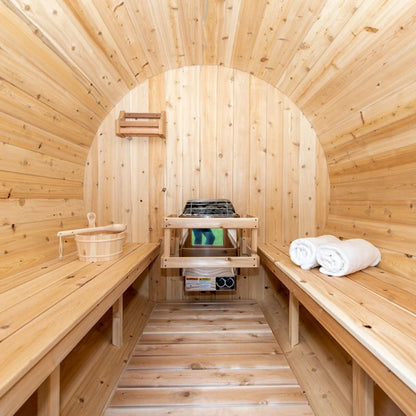 Inside the CT Serenity barrel sauna: facing cedar benches, heater and slatted floor