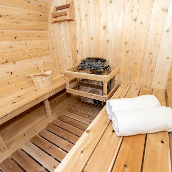 Electric heater with stones and a cedar bucket inside the CT Serenity barrel sauna