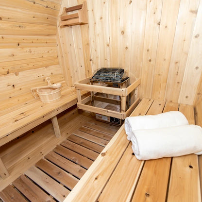 Electric heater with stones and a cedar bucket inside the CT Serenity barrel sauna