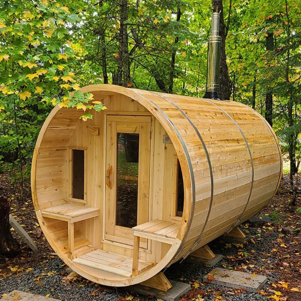 CT Tranquility barrel sauna among autumn trees with a wood-burning chimney fitted
