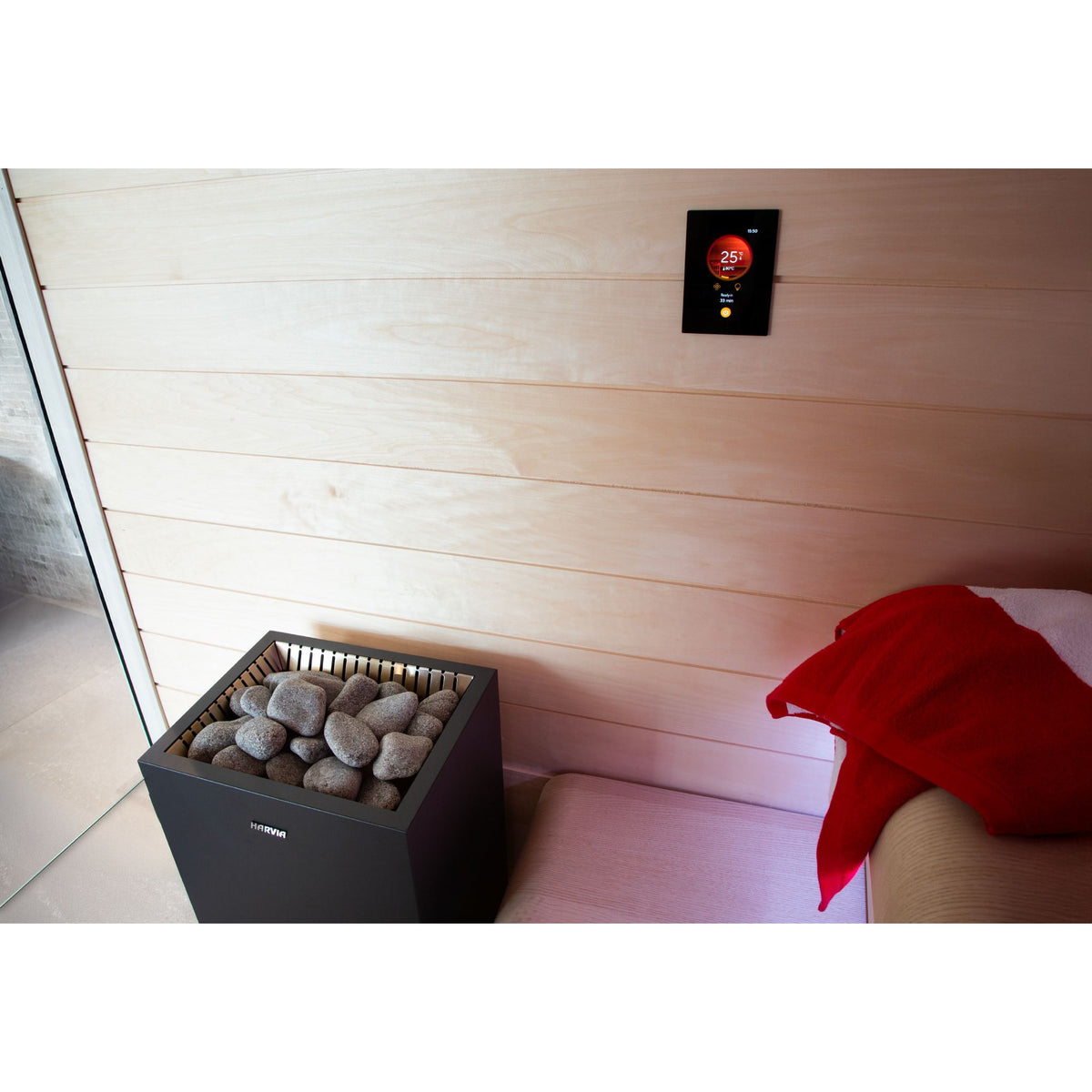Harvia Fenix control panel mounted high on a light timber sauna wall above an electric heater