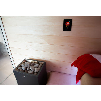 Harvia Fenix control panel mounted high on a light timber sauna wall above an electric heater