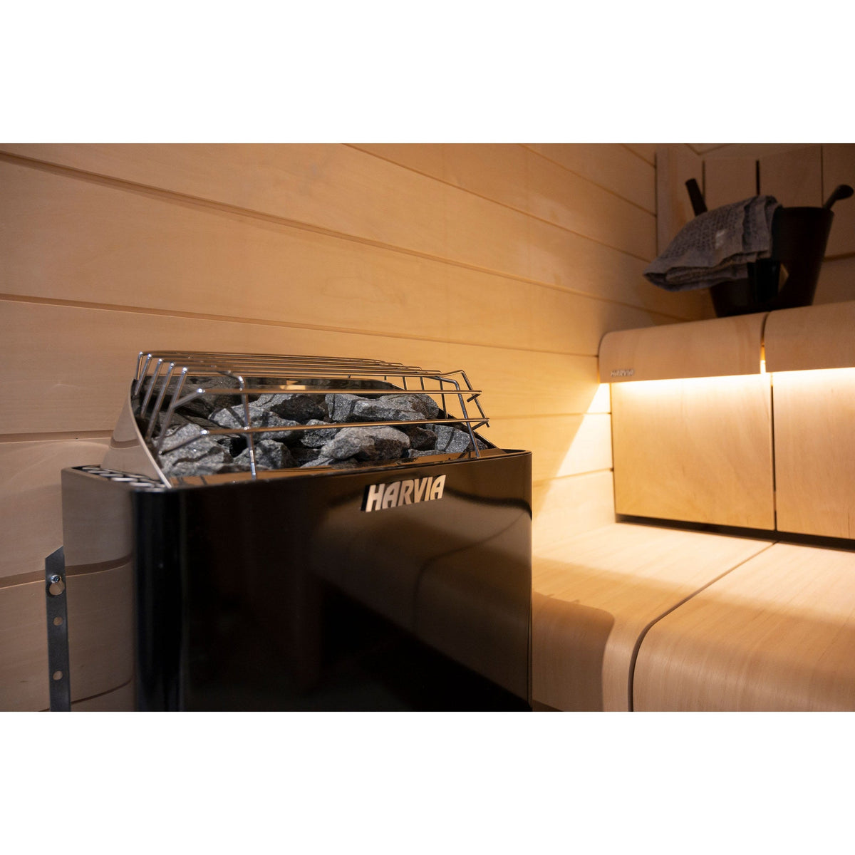 Harvia KIP80B 8kW in graphite black beside the sauna bench