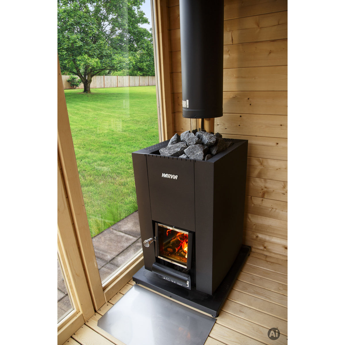 Harvia Linear 18 Compact Black 14.3kW in a sauna beside a glass door with a garden view