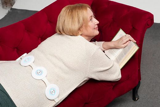 ALMAG-01 PEMF coil emitters positioned on upper back — traveling magnetic field therapy session