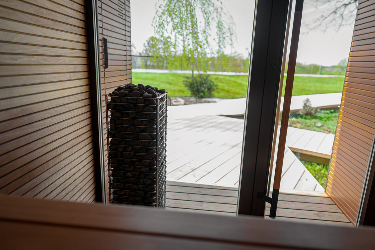 HUUM CLIFF heater by an open glass sauna door