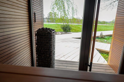 HUUM CLIFF heater by an open glass sauna door