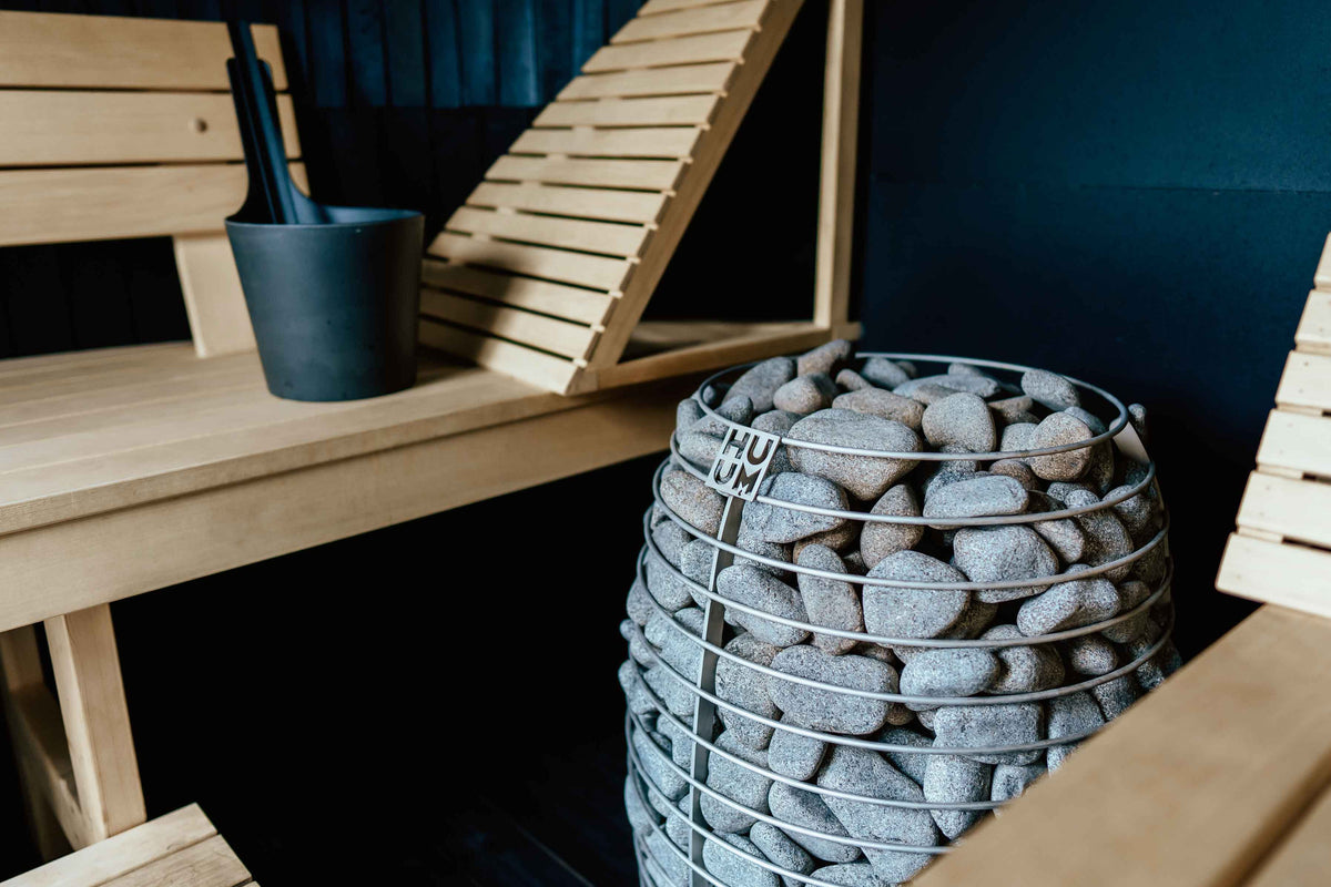 HUUM HIVE heater in a sauna with a dark wall