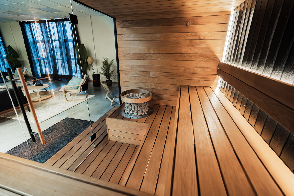 HUUM HIVE Mini set into a wooden bench surround in a glass-fronted sauna